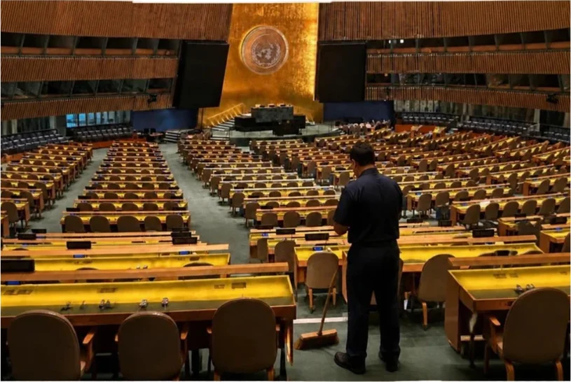 Funcionário da limpeza diante das fileiras vazias do plenário da Assembleia Geral da ONU
